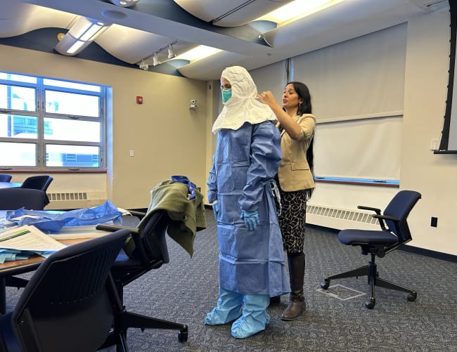 A volunteer is guided through the full donning sequence for special pathogen personal protective equipment during a training seminar led by Syra Madad, chief biopreparedness officer for NYC Health + Hospitals, on February 2, 2026.