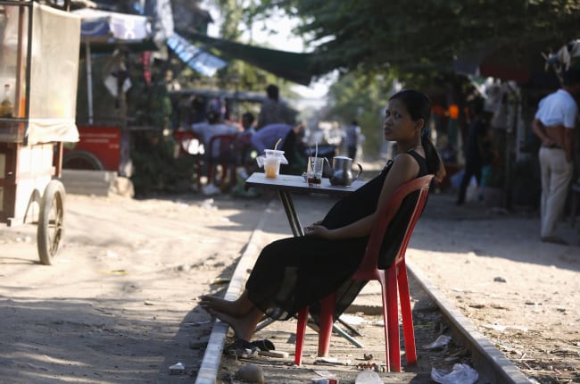 A pregnant woman rests on the railway track in front of her home, in Phnom Penh, Cambodia, on February 4, 2016.