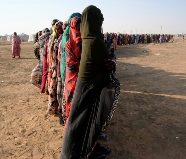 Displaced women stand in a long queue to receive food supplies at a displacement camp, in Al-Dabbah, Sudan, on November 13, 2025.