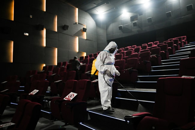 A worker in personal protective equipment disinfects a cinema in preparation for the reopening of movie theaters, as the country's capital region loosens coronavirus disease restrictions, at Eastwood Mall, in Quezon City, Philippines, on October 16, 2021.