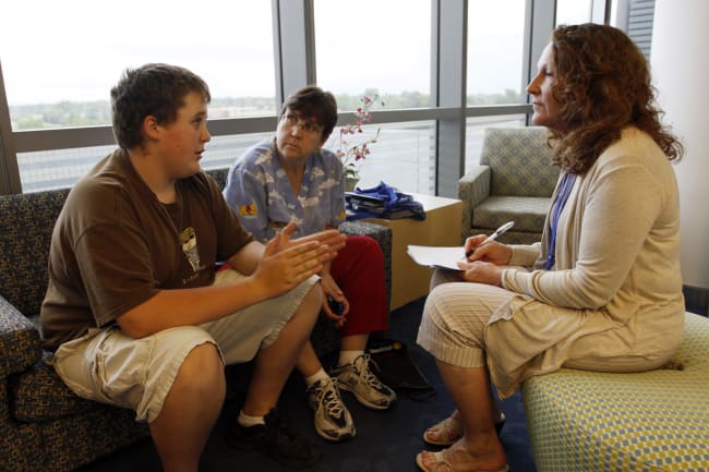 Micah Peterson, 15, and his mother talk with Marilyn Day, director of a child and teen weight management program, during a counseling session at The Children's Hospital, in Aurora, Colorado, on July 8, 2010.