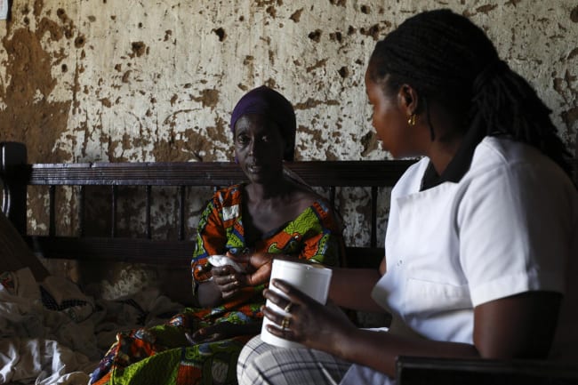 A Service Yezu Mwiza nurse hands medication to an HIV patient, who is also suffering from malaria, at her home, in Gatumba, Burundi, on April 19, 2013.