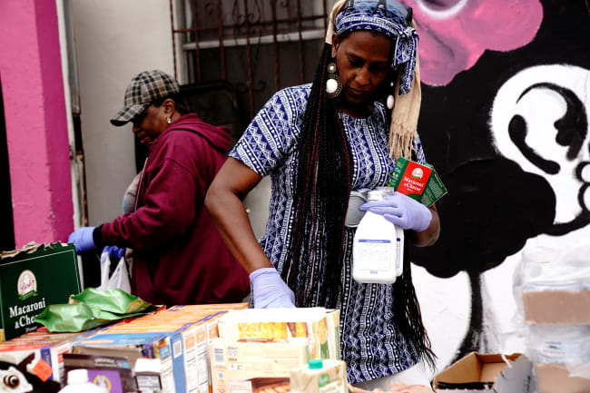 A volunteer grips bottles of Similac baby formula while preparing aid packages for people experiencing food insecurity at a give-away of food and baby formula held by the San Diego Original Black Panther Party for Community Empowerment, in San Diego, California, on May 25, 2022.