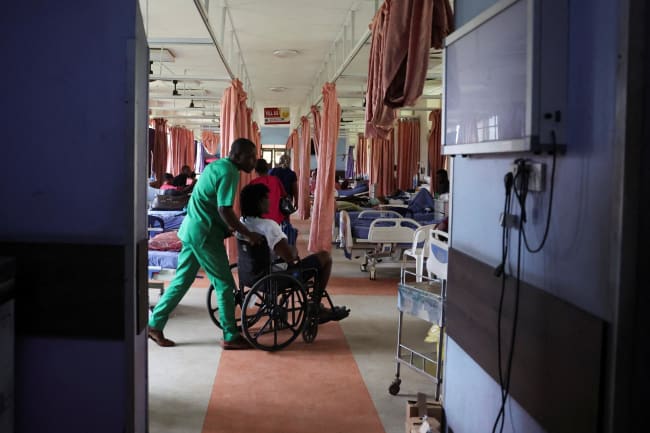 An injured patient is wheeled out of the out-patient ward of the National Orthopaedic Hospital, in Lagos, Nigeria, on July 30, 2025.