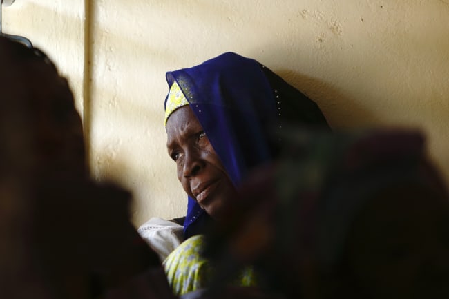 A woman gazes out of a window while attending a talk on sexual health and HIV prevention, in the Tanghin neighborhood of Ouagadougou, Burkina Faso, on April 13, 2013.