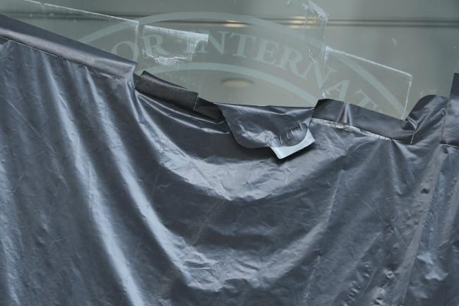 Plastic peels back to reveal the covered logo on the windows of the shuttered offices of the U.S. Agency for International Development, in Washington, DC, on July 22, 2025.