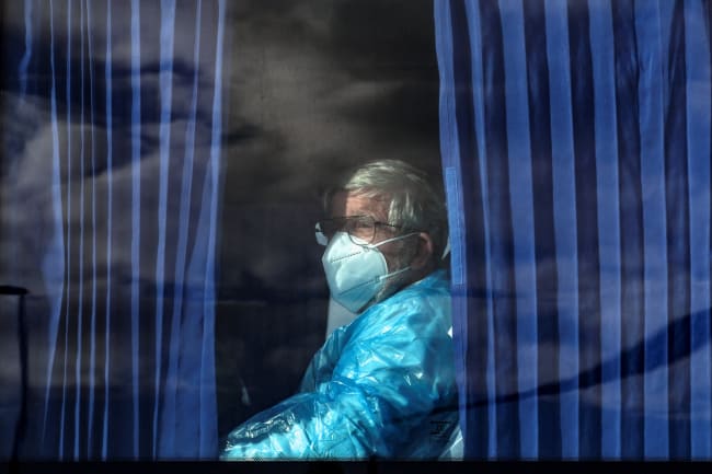 A passenger of the cruise ship MV Hondius, affected by a hantavirus outbreak, looks on from inside a bus as it leaves the port of Granadilla de Abona, in Tenerife, Spain, on May 11, 2026.