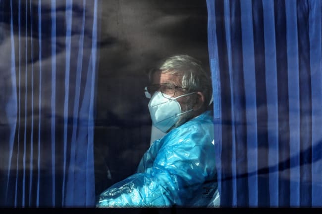A passenger of the cruise ship MV Hondius, affected by a hantavirus outbreak, looks on from inside a bus as it leaves the port of Granadilla de Abona, in Tenerife, Spain, on May 11, 2026.