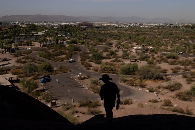 A man walks on a trail during a 27 days long heat wave with temperatures over 110 degrees Fahrenheit (43 degrees Celsius), in Phoenix, Arizona, on July 26, 2023.