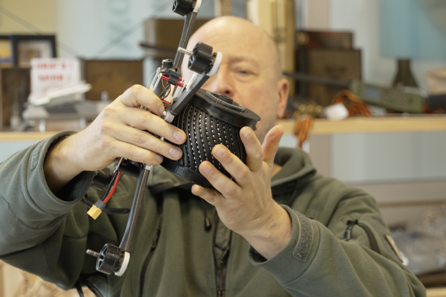NGO Blue/Yellow co-founder Jonas Ohman puts an inert, drone-carried explosive on a drone at the NGO headquarters in Vilnius, Lithuania, in March 2026.