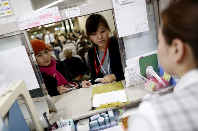 Dang Nguyen Thuc Vien, a 32-year-old daughter of refugees from south Vietnam, helps a local Vietnamese resident in Japan as an interpreter at a hospital, in Kanagawa prefecture, Japan, on November 25, 2015.