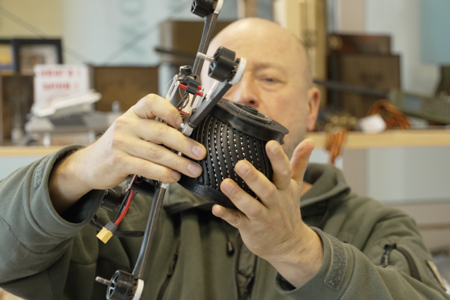 NGO Blue/Yellow co-founder Jonas Ohman puts an inert, drone-carried explosive on a drone at the NGO headquarters in Vilnius, Lithuania, in March 2026.