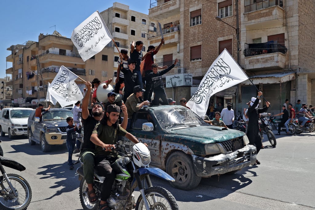 A photo of members of Syria's top jihadist group the Hayat Tahrir al-Sham (HTS) alliance waving flags