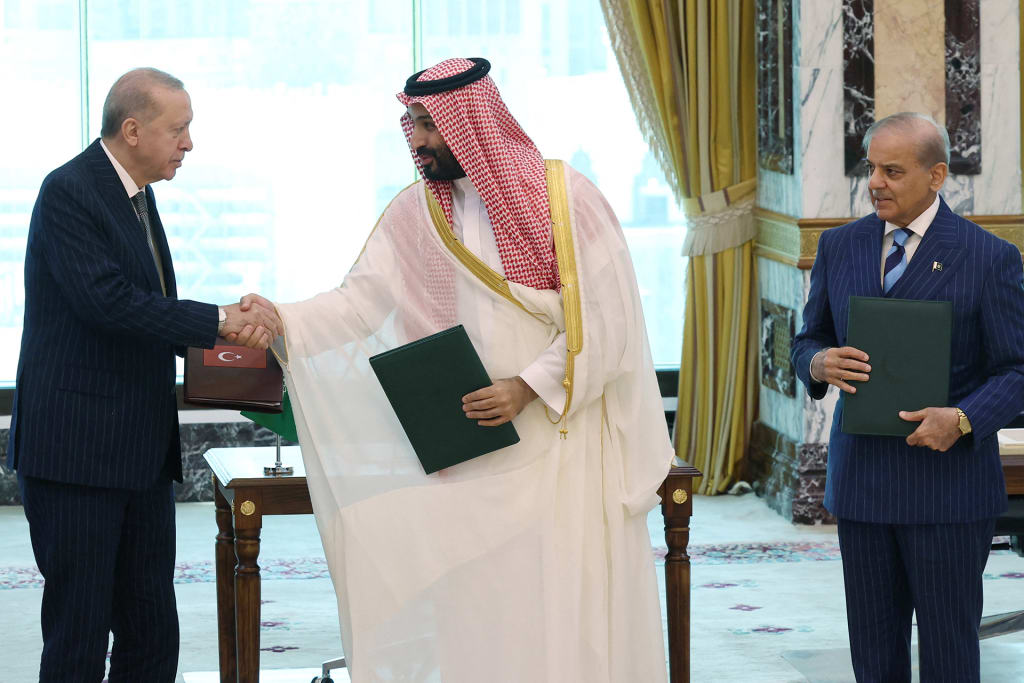Turkish President Recep Tayyip Erdogan shakes hands with Saudi Crown Prince Mohammed bin Salman as Pakistani Prime Minister Shehbaz Sharif looks on after signing a joint defense agreement in Mecca, Saudi Arabia, August 7, 2026.