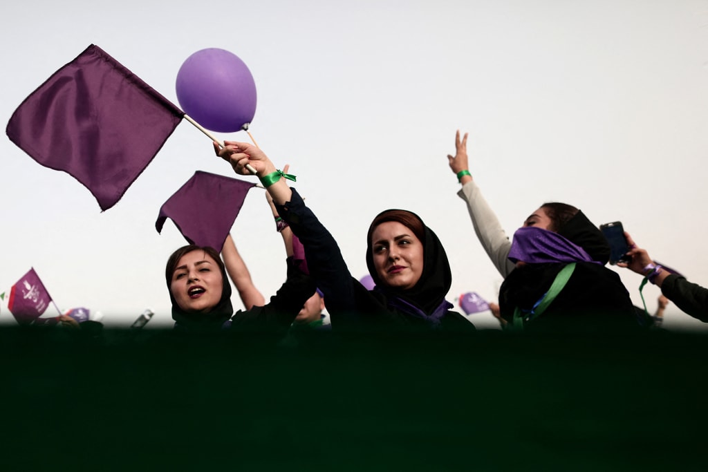 Supporters of Iranian President and candidate in the presidential elections, Hassan Rouhani, cheer during a campaign rally at Takhti Stadium in the southwestern Iranian city of Ahvaz on May 16, 2017.