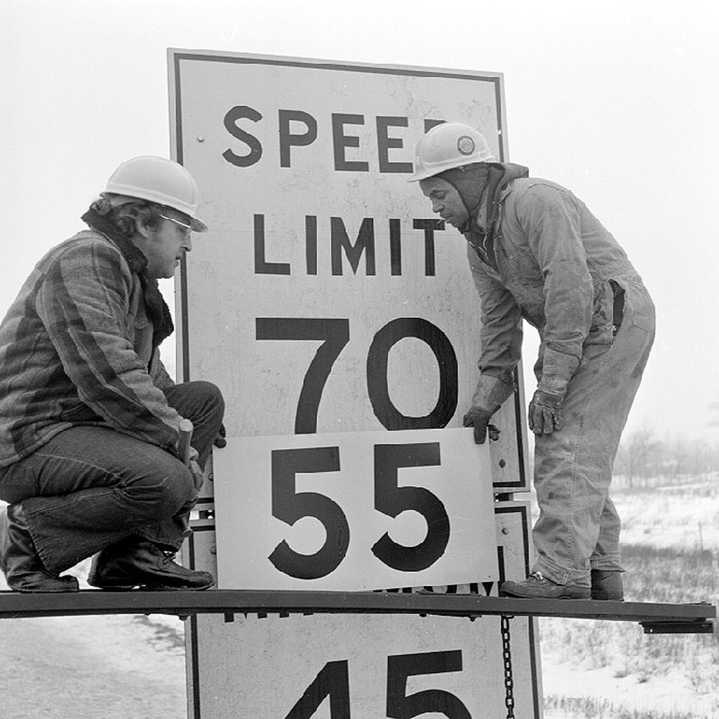 Highway workers change a speed limit sign from 70 mph to the new federally mandated limit of 55 mph on February 12, 1974. 
