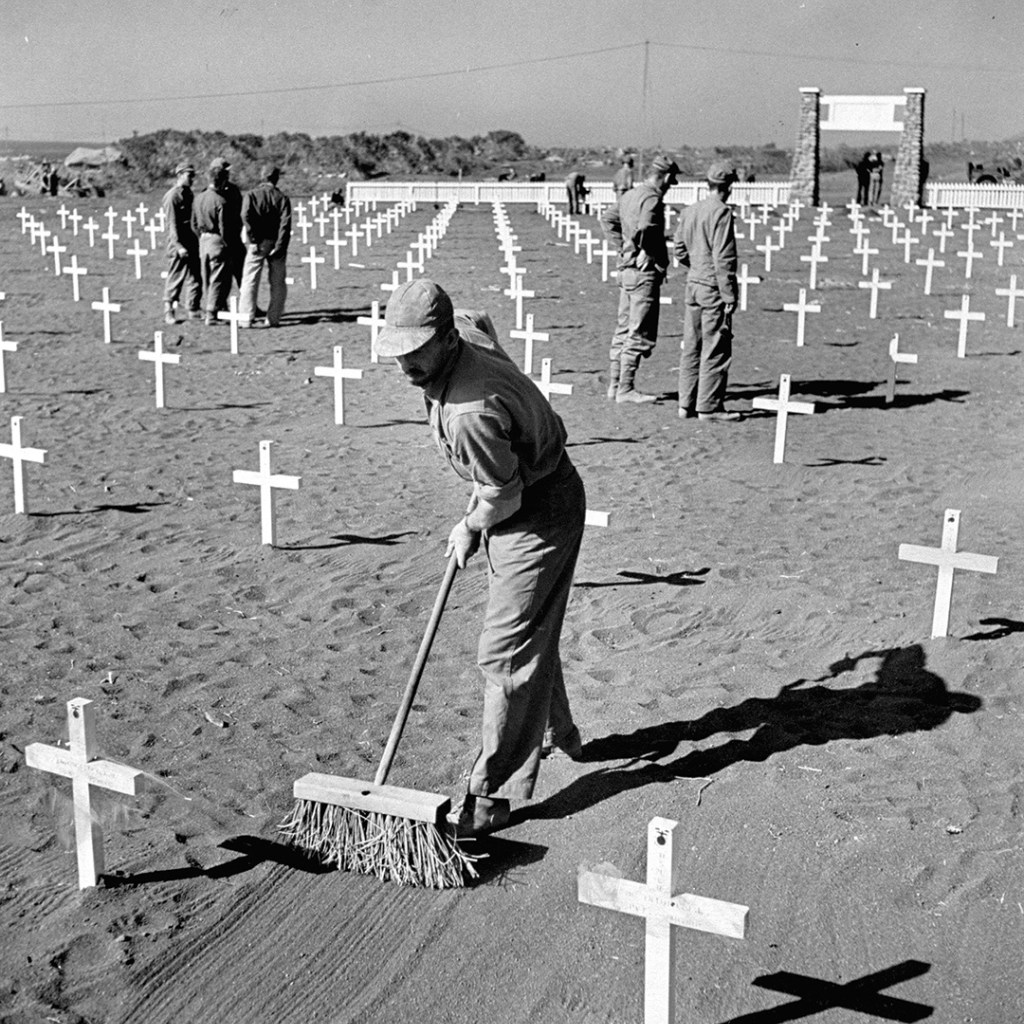 A U.S. Marine smooths the sand at a fifth division cemetery in Iwo Jima after the battle for control of the island.
