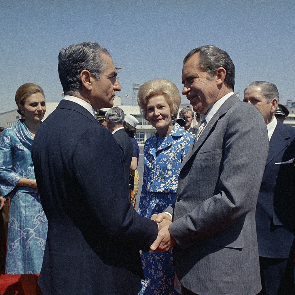 U.S. President Richard Nixon clasps the shah’s hand as he and First Lady Patricia Nixon prepare to depart from Iran. 

