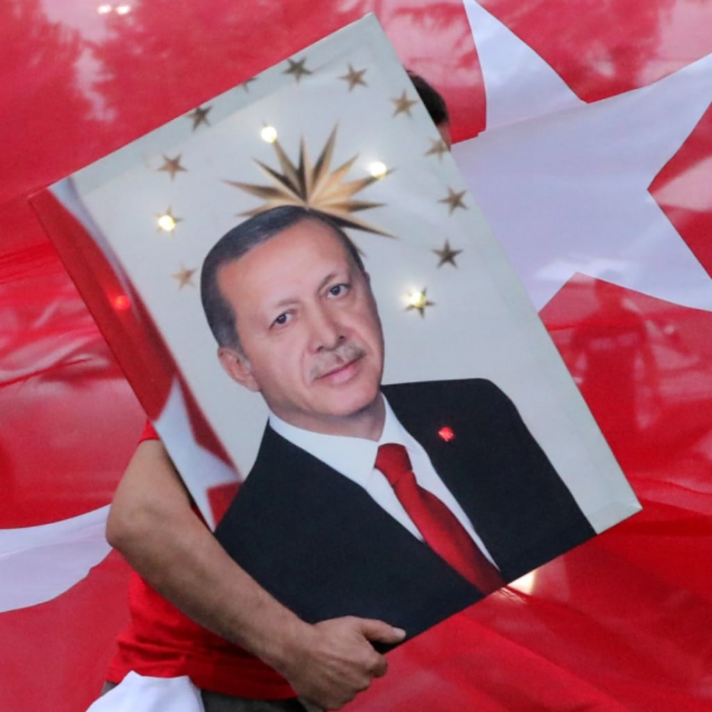 <p>A supporter of Turkish President Recep Tayyip Erdogan holds his picture in front of a Turkish flag in Istanbul.</p>