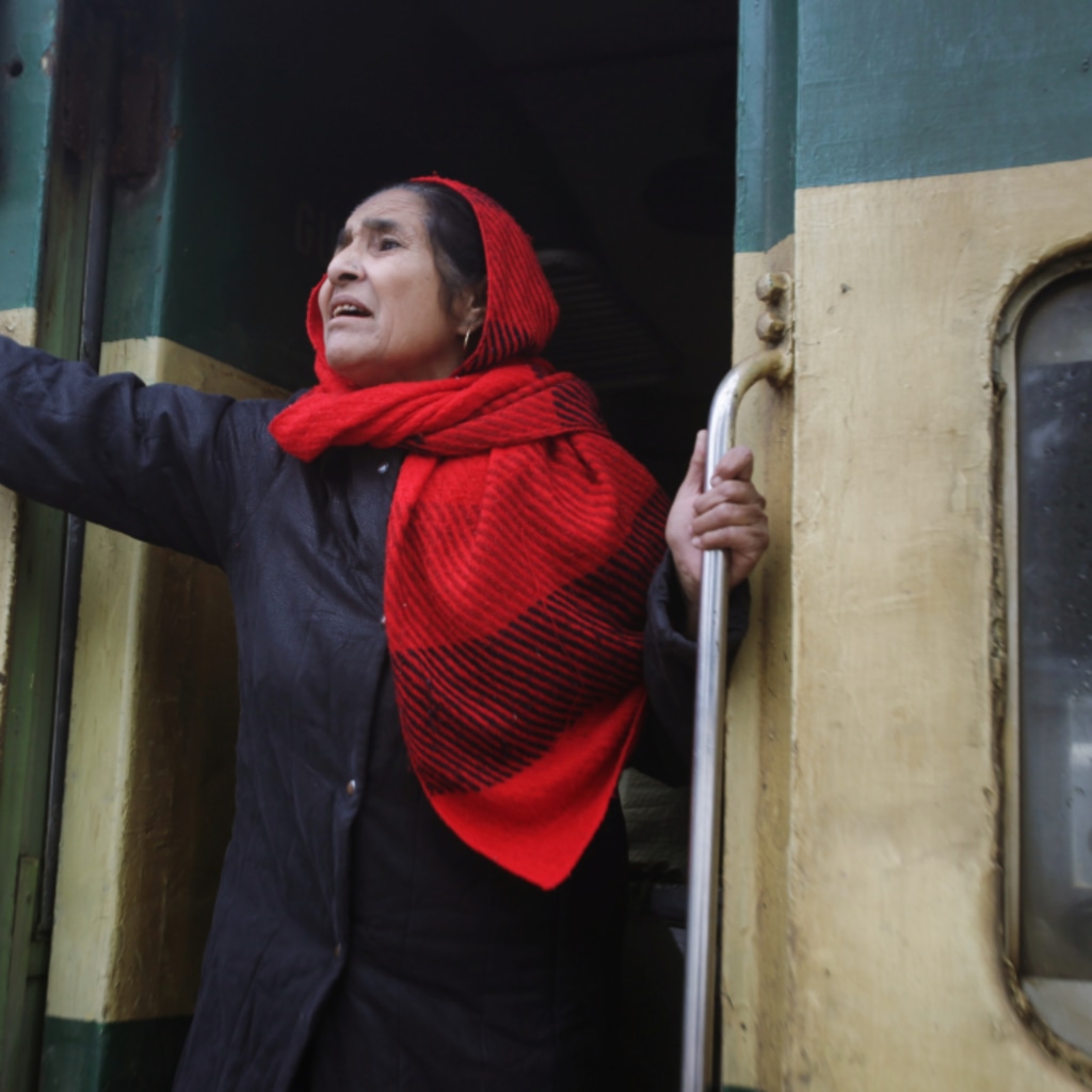<p>An Indian woman gestures to her relatives as she leaves a railway station in Lahore, Pakistan.</p>
