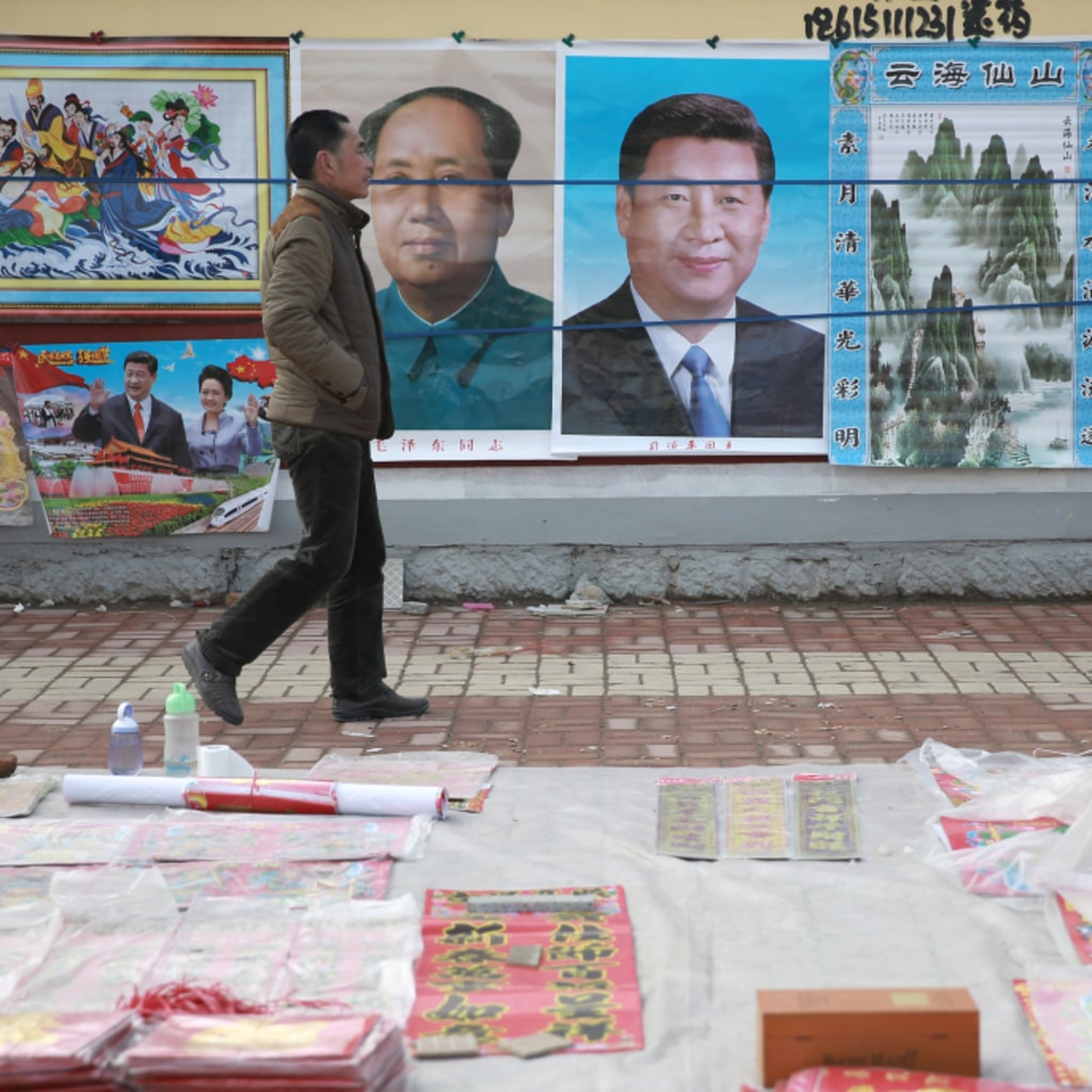 <p>A man walks past New Year decoration pictures featuring China’s President Xi Jinping, China’s late Chairman Mao Zedong and some other current senior officials, at a market in Juancheng, Shandong province, February 17, 2015. The Chinese Lunar New Year on F</p>