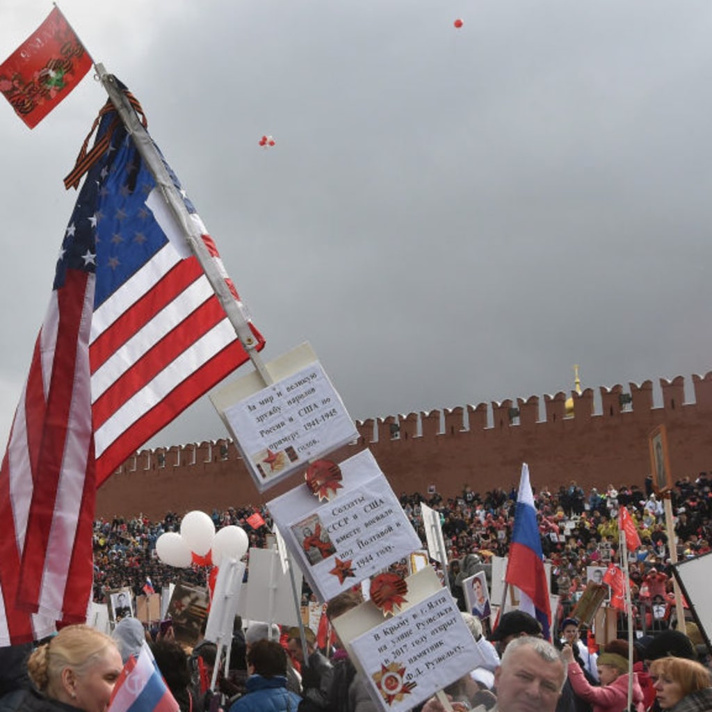 <p>People carry portraits of relatives who fought in World War II and the U.S. flag to mark the Allied victory in World War II, with the Kremlin in the background on May 9, 2017 in Moscow, Russia. </p>
