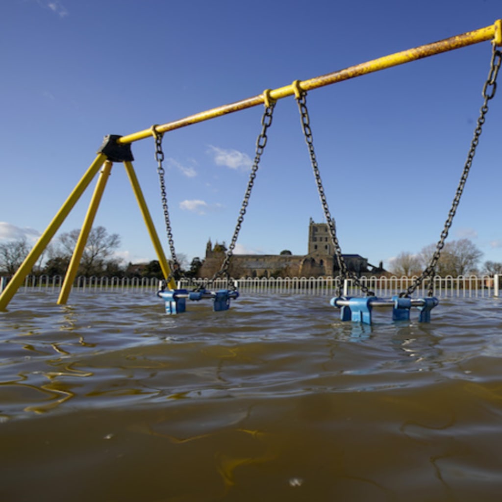 <p>TEWKESBURY, ENGLAND – FEBRUARY 27: Tewkesbury Abbey and a children’s playground at the confluence of the Rivers Severn and Avon, is surrounded by flood waters on February 27, 2020 in Tewskesbury, England. Flooding levels are decreasing after storms Ciara </p>
