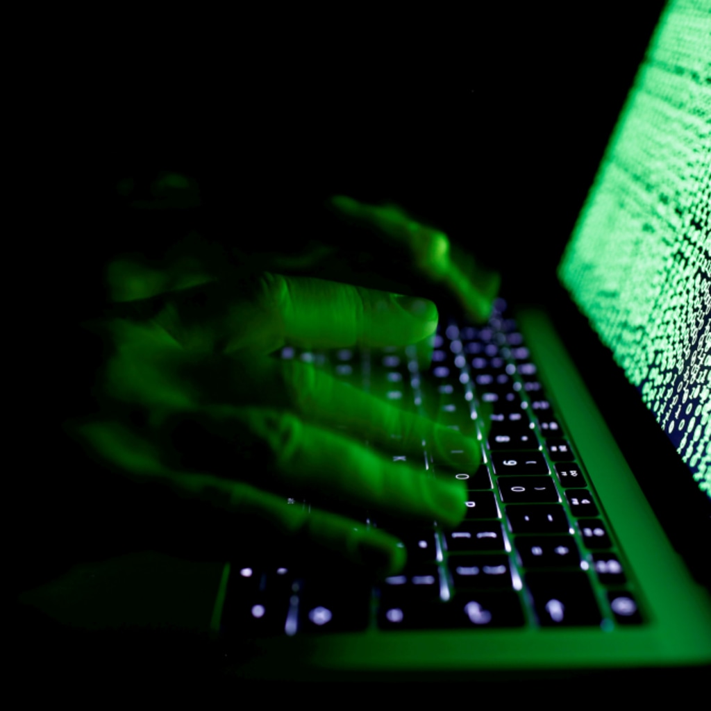 <p>A man types on a computer keyboard in front of the displayed cyber code. </p>

