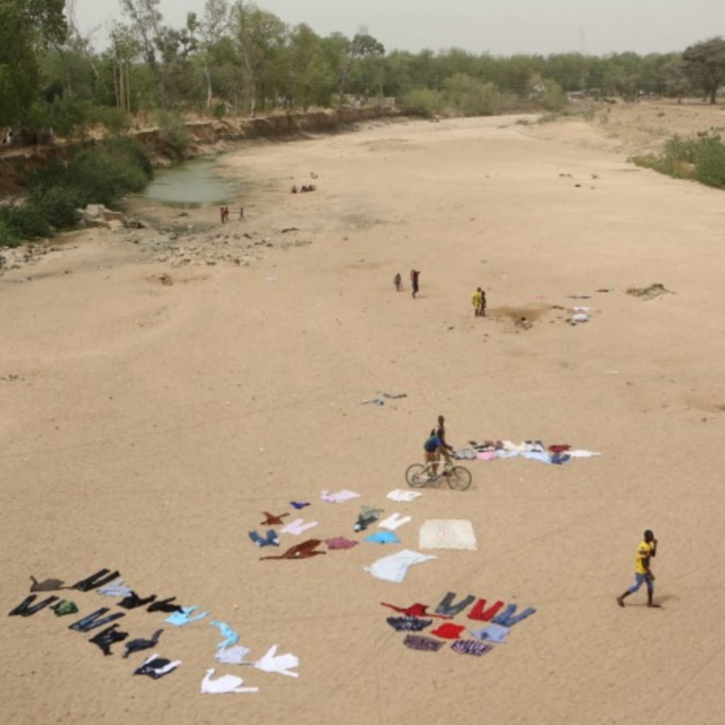 <p>People wash clothes in a dry riverbed in Maroua, Cameroon, March 17, 2016. (Reuters/Joe Penney)</p>
