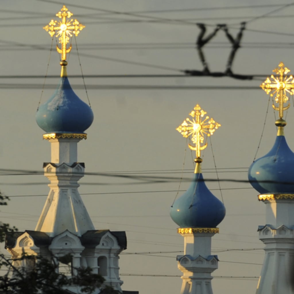<p>A Russian policeman passes an Orthodox church during a demonstration to support political prisoners in Moscow.</p>