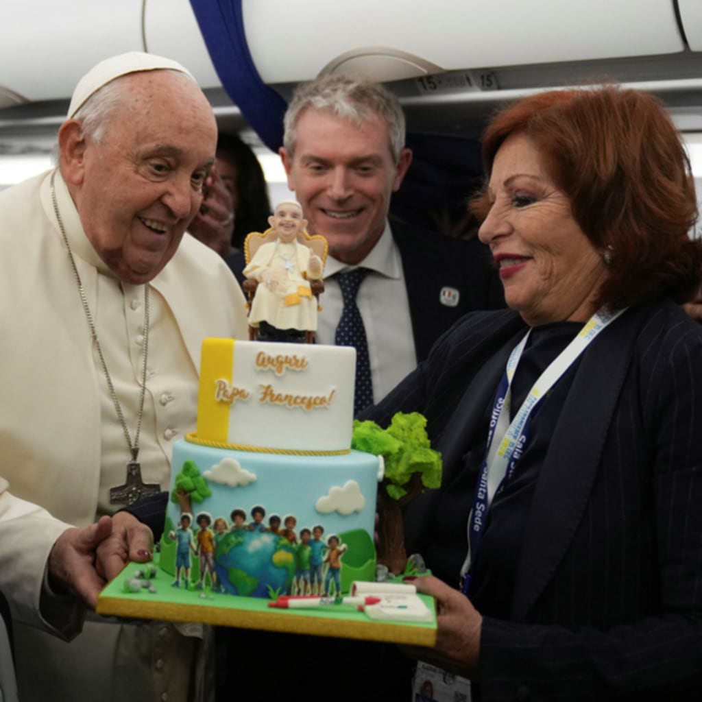 <p>Pope Francis is presented with a cake by Valentina Alazraki, correspondent for TeleVisa Univision, to celebrate his upcoming 88th birthday, on the flight back to Rome at the end of his one-day visit to Ajaccio in the French island of Corsica, December 15,</p>