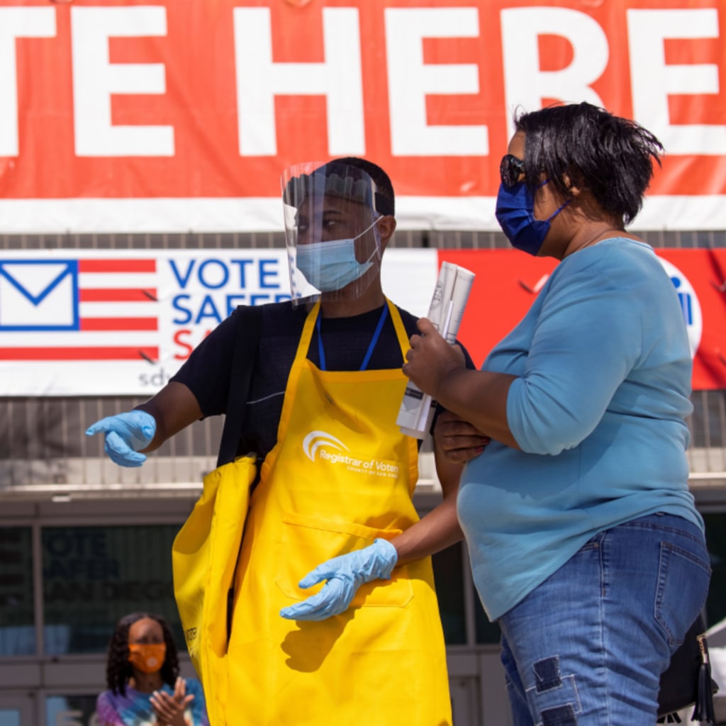 <p>An election worker guides voters where to register to vote at the Registrar of Voters for San Diego County in San Diego, California, U.S.</p>
