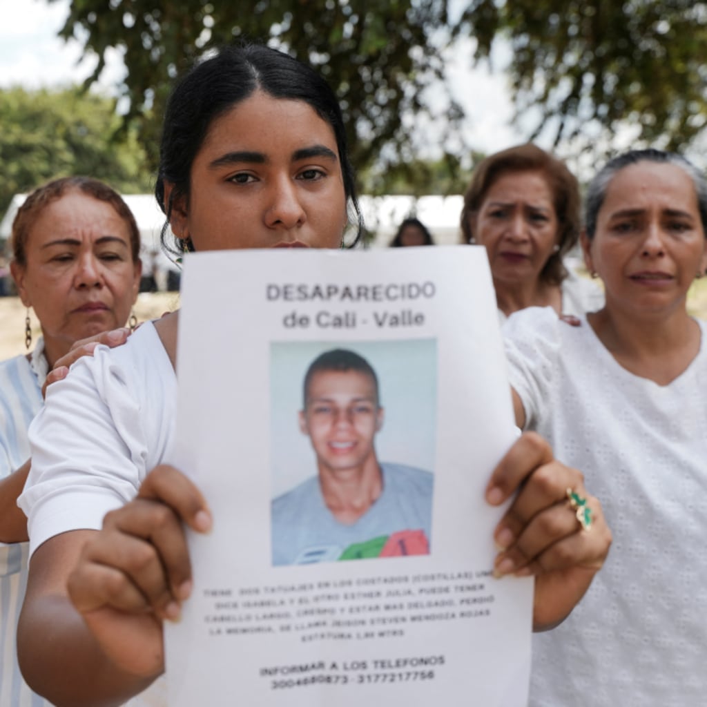 A woman holds a picture of a victim of forced disappearance during a 2025 ceremony in Colombia to honor loved ones who remain missing.