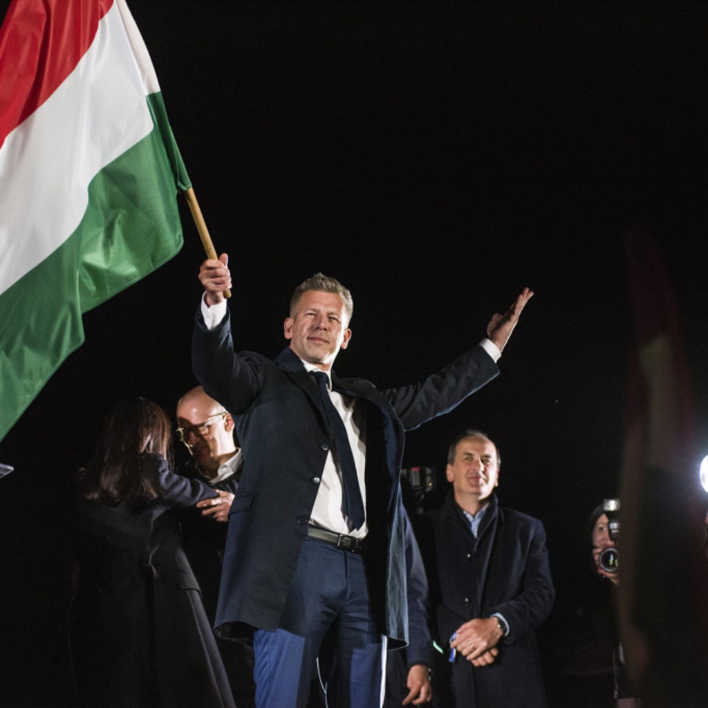 Peter Magyar waves the Hungarian flag after his speech during his party's election night event in Budapest on Sunday, April 12, 2026.