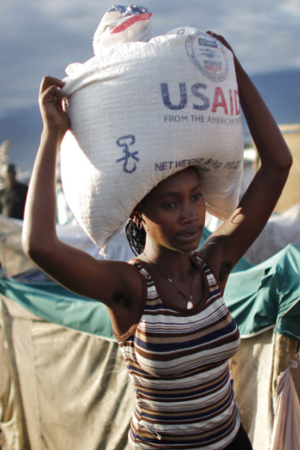 <p>A woman carries a bag of rice distributed by the U.S. Agency for International Development (USAID) in Port-au-Prince, Haiti. </p>