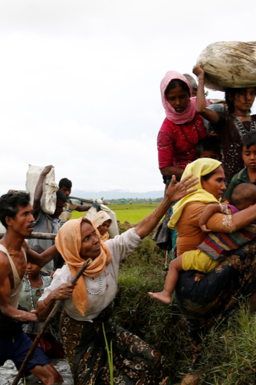 <p>Rohingya refugees help each other after crossing the Bangladesh-Myanmar border.</p>