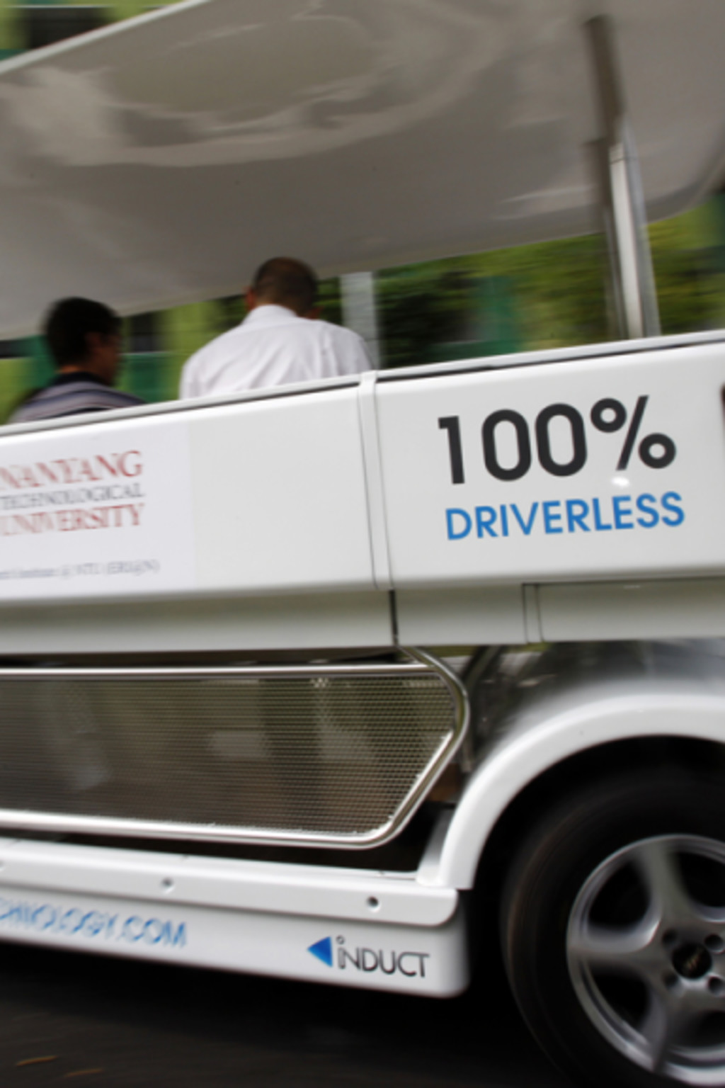 <p>People ride on a driverless electric vehicle at the Nanyang Technological University (NTU) in Singapore.</p>
