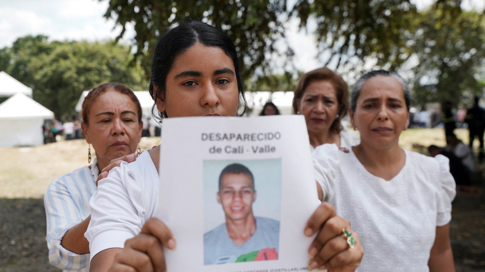 A woman holds a picture of a victim of forced disappearance during a 2025 ceremony in Colombia to honor loved ones who remain missing.