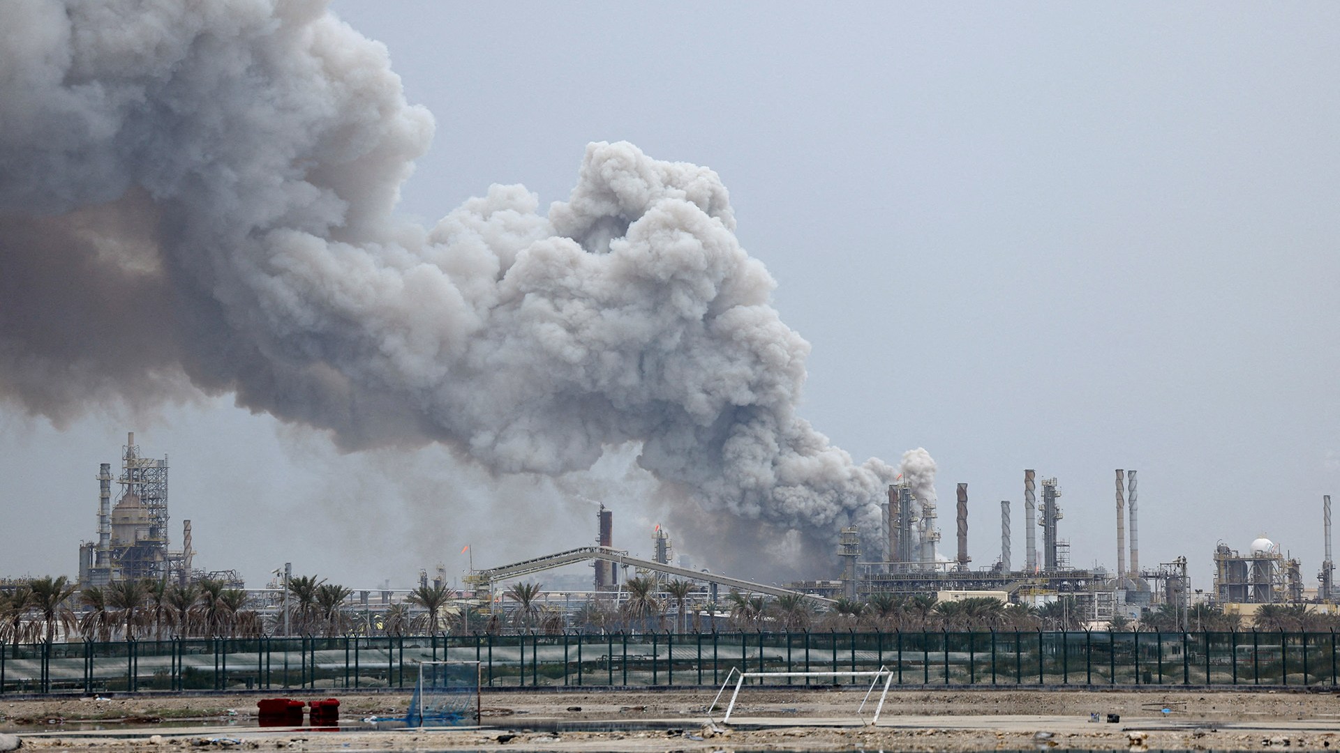 <p>A person rides on a scooter as smoke rises in the Fujairah oil industry zone following a fire caused by debris after interception of a drone by air defenses, in Fujairah, United Arab Emirates, March 3, 2026.</p>
