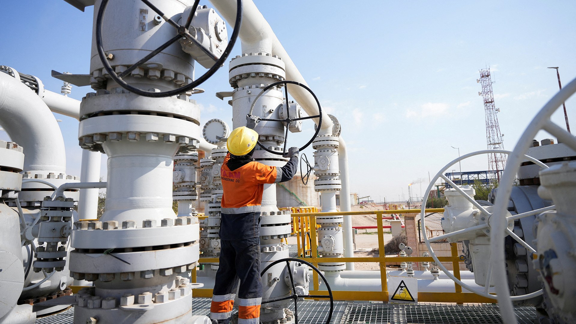 A worker operates valves at the Rumaila oil field, as the country cuts nearly 1.5 million barrels per day of output amid halted exports following the closure of the Strait of Hormuz, in Basra, Iraq, on March 4, 2026. 