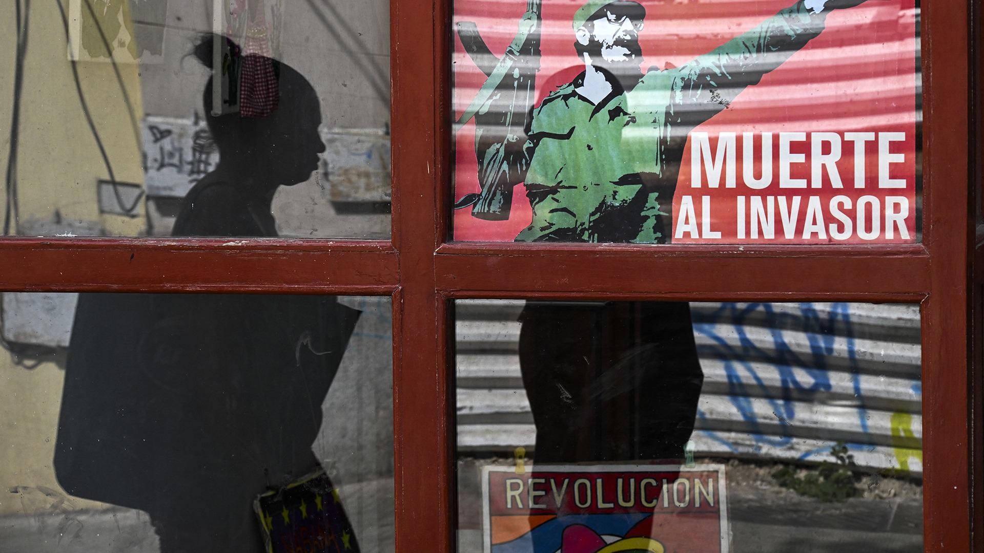 <p>A woman walks past a poster of late Cuban leader Fidel Castro reading, “Death to the invader” in Havana, on March 13, 2026.</p>
