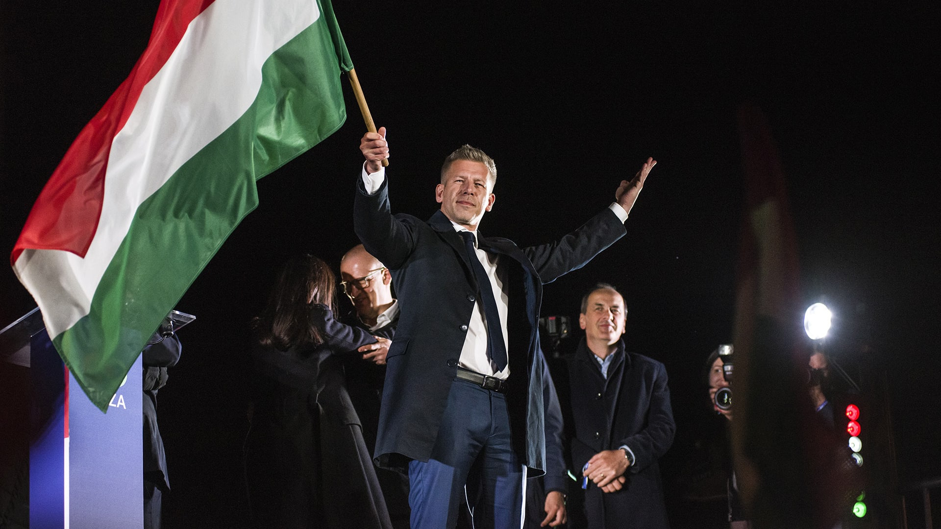 Peter Magyar waves the Hungarian flag after his speech during his party's election night event in Budapest on Sunday, April 12, 2026.