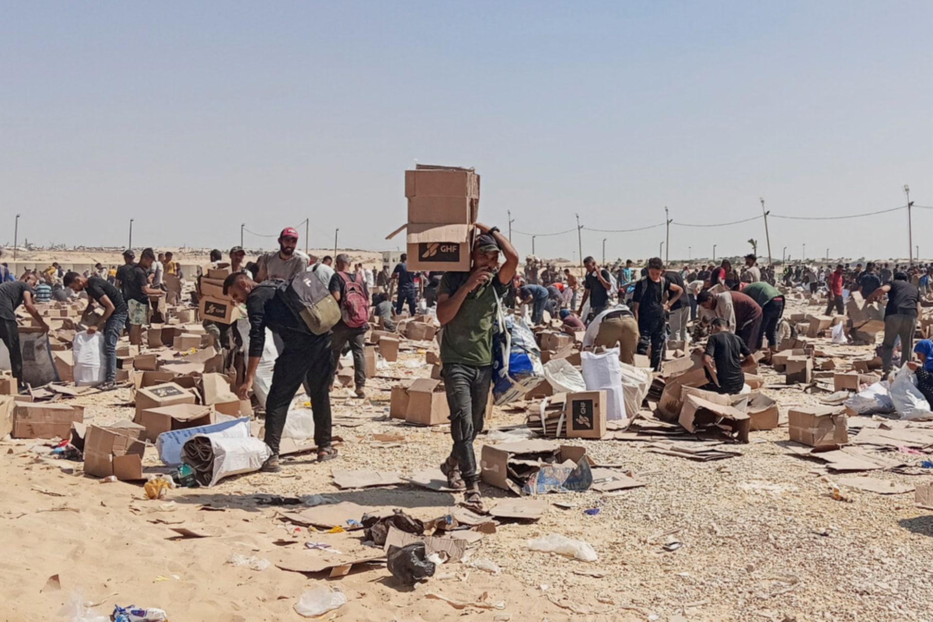 <p>Palestinians collect what remains of relief supplies from the distribution center of the U.S.-backed Gaza Humanitarian Foundation, in Rafah, in the southern Gaza Strip, June 5, 2025.</p>
