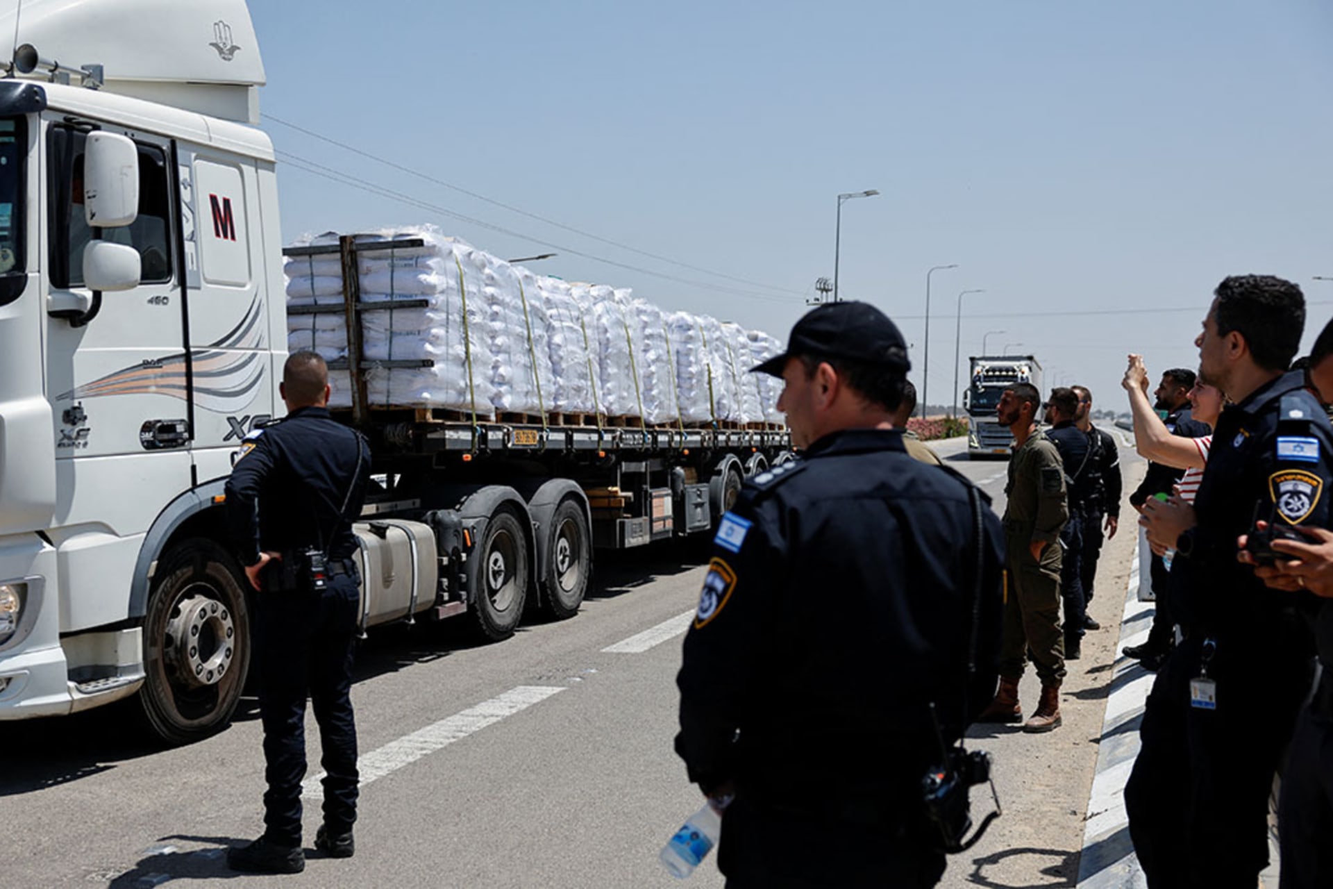 <p>Members of the Israeli security forces stand near trucks carrying aid entering Gaza from Israel, at the Kerem Shalom crossing on the Israeli-Gaza border, May 21, 2025.</p>

