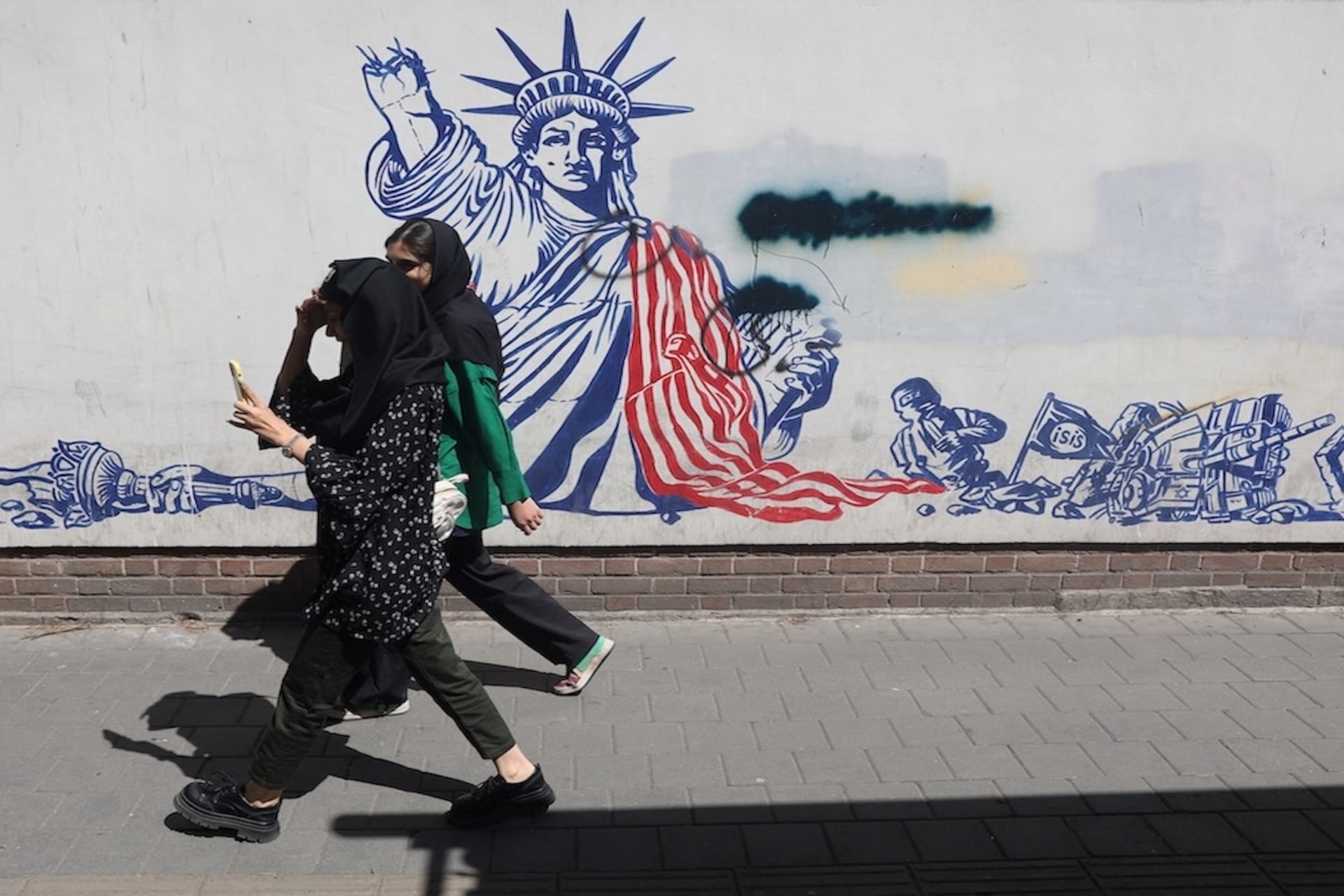 <p>People walk past an anti-U.S. mural on a street in Tehran, Iran, April 19, 2025.</p>
