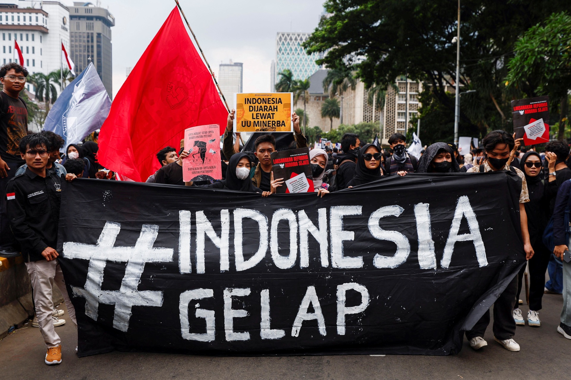<p>People holding a banner and placards march during an anti-government protest called ‘Indonesia Gelap’ (Dark Indonesia), against the recent budget cuts and other policies, near the presidential palace in Jakarta, Indonesia, on February 21, 2025. </p>