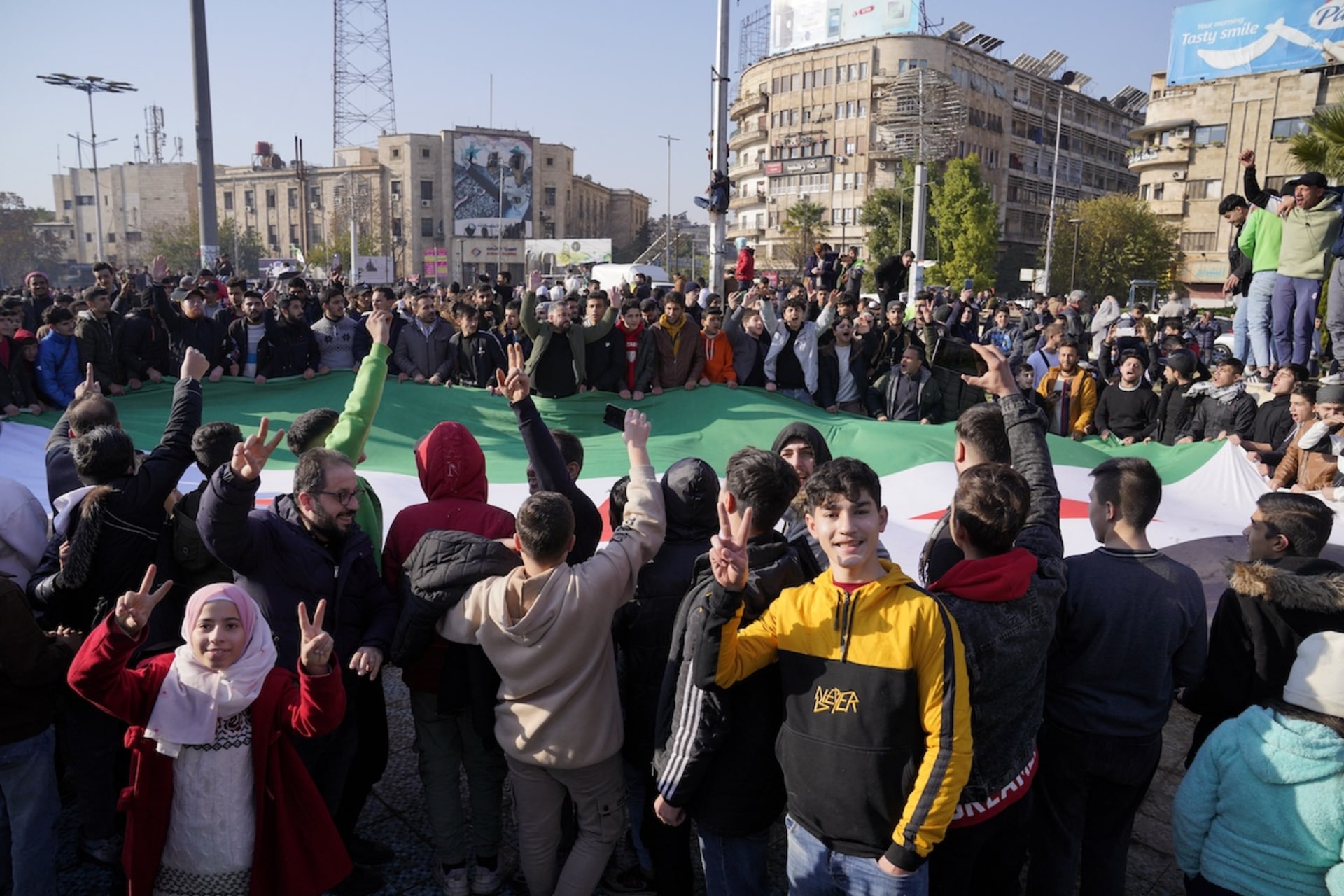 <p>People hold the Syrian opposition flag in Aleppo as they celebrate the end of President Bashar al-Assad’s 24-year authoritarian rule, on December 8, 2024.</p>