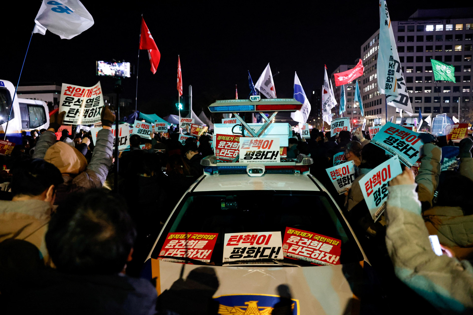 <p>Placards are placed on a police vehicle as people they gather outside the National Assembly, after South Korean President Yoon Suk Yeol declared martial law</p>