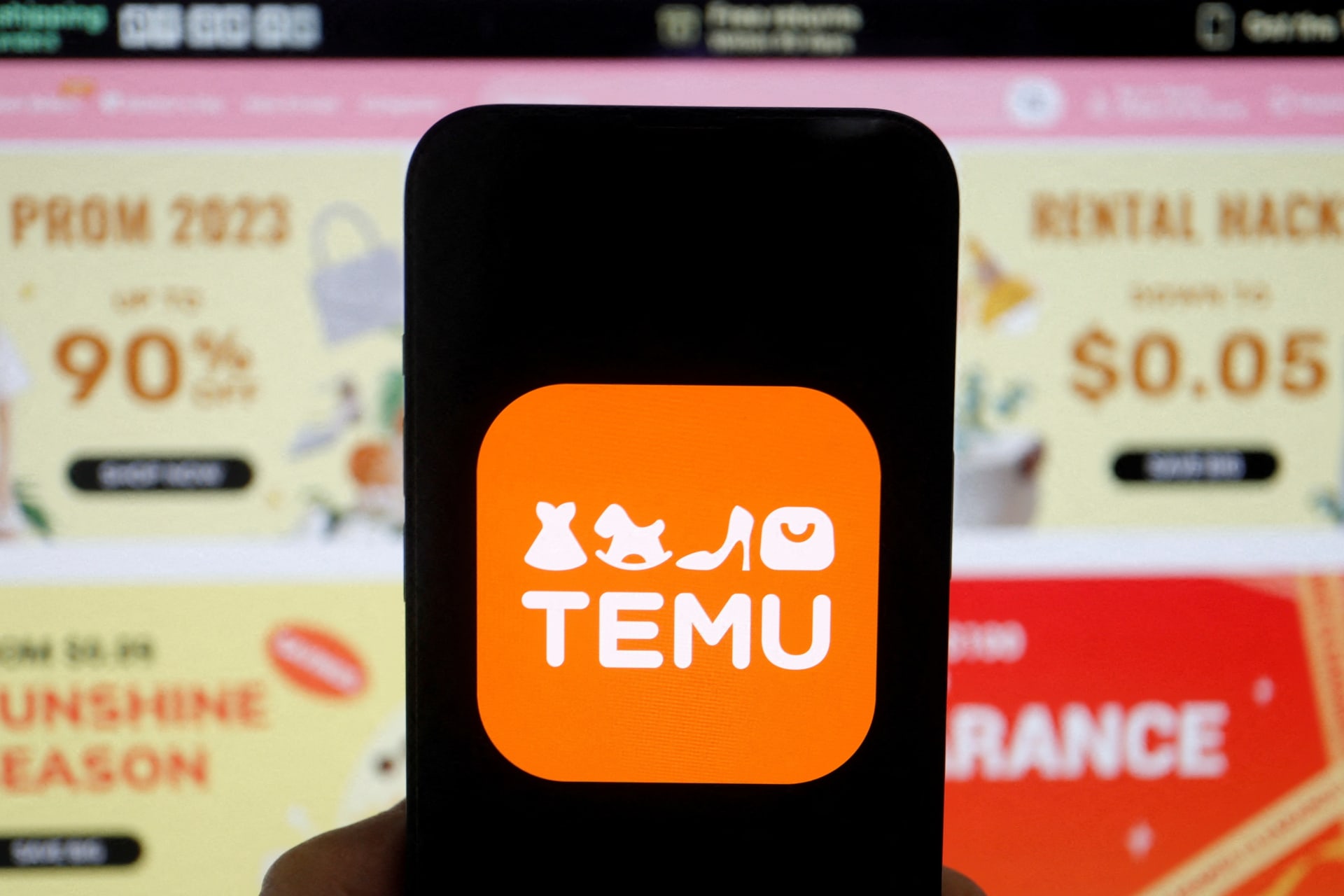 <p>The logo of Temu is seen on a mobile phone displayed in front of its website, in this illustration picture taken April 26, 2023.</p>