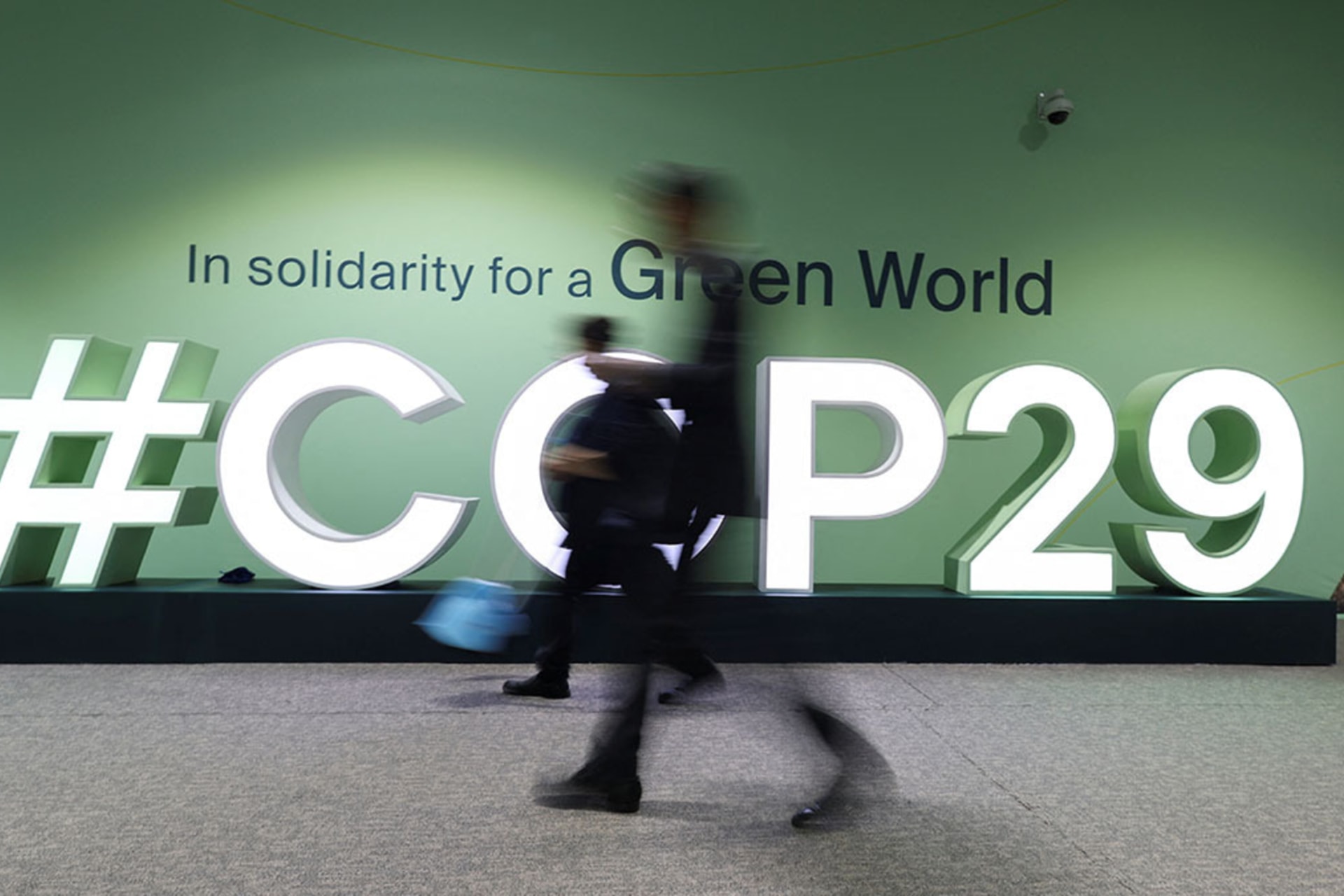 <p>People walk past a COP29 logo during the United Nations Climate Change Conference (COP29), in Baku, Azerbaijan.</p>
